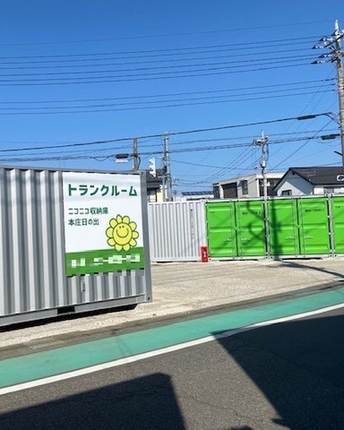 ニコニコ収納庫　本庄日の出 太陽マークの看板と明るい緑の扉が目印です